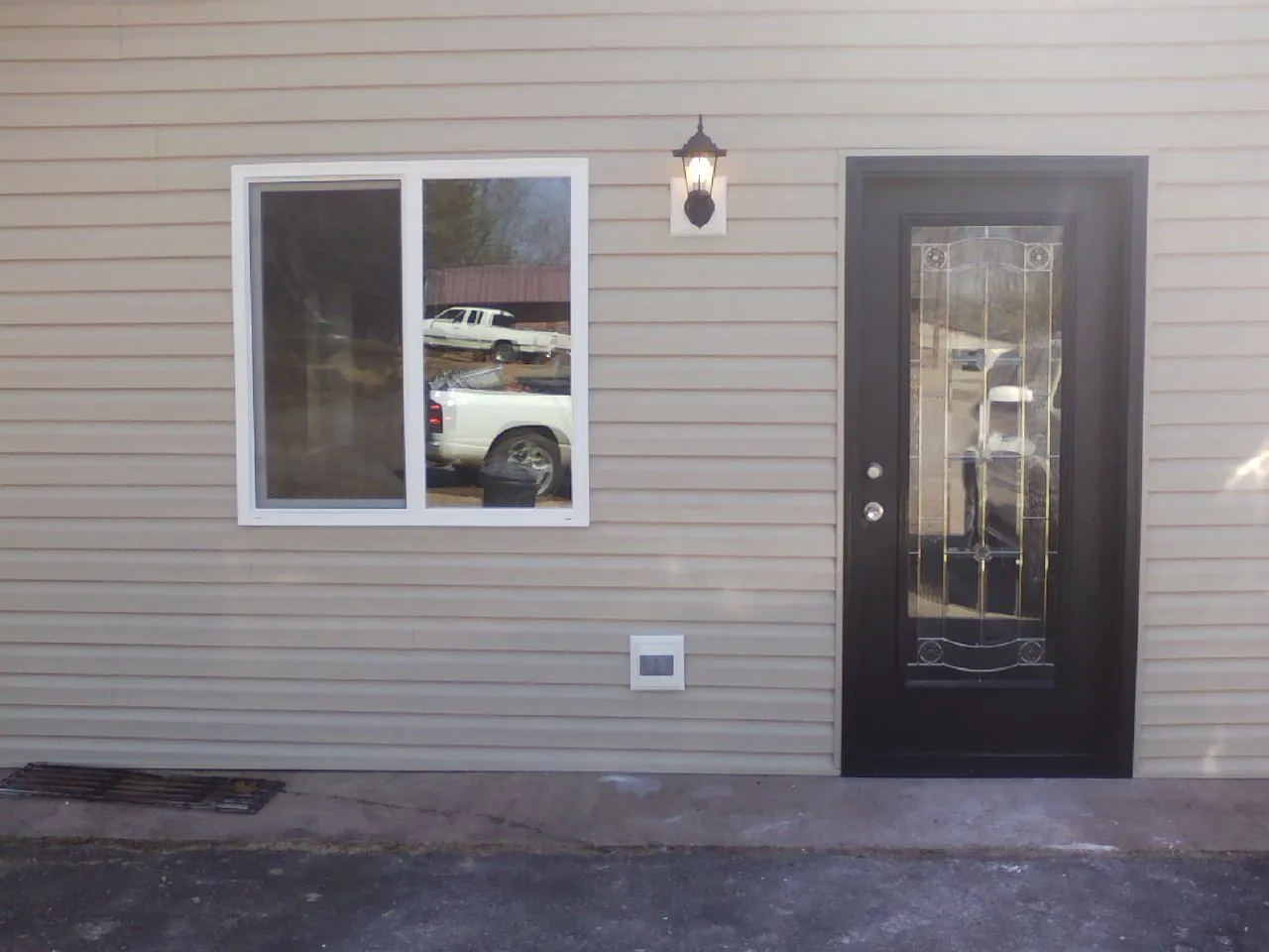 New siding, window and entry door on the side of an addition in Vernon